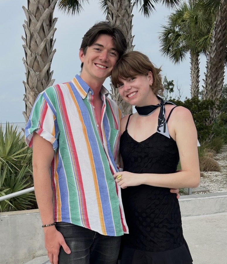 Elizabeth and Nicholas standing under palm trees on the Florida coast.